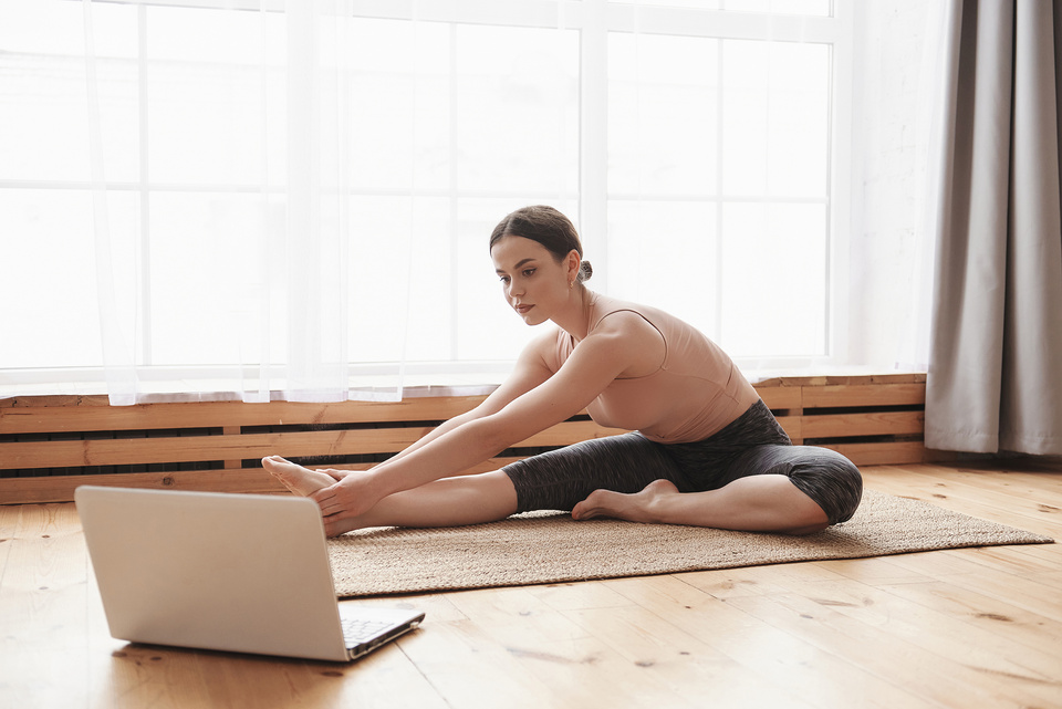 Young woman practicing yoga online